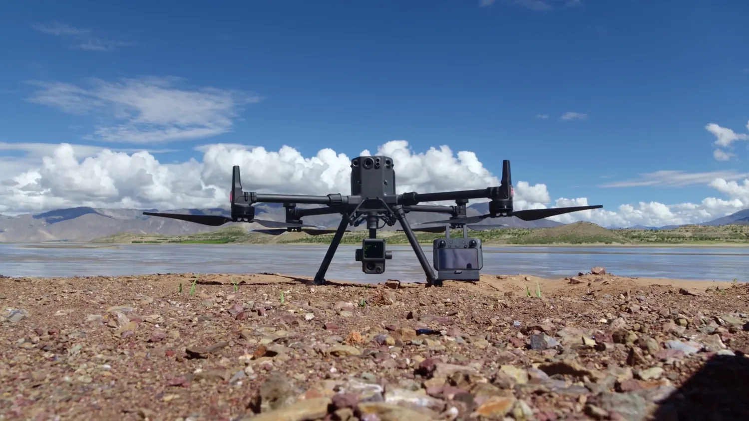 Matrice 350 RTK drone and base station set up on the ground beside a lake with mountains in Costa Rica